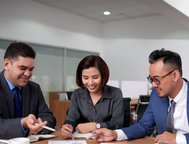 A diverse team of colleagues collaborating and discussing business data and charts in a modern office setting.